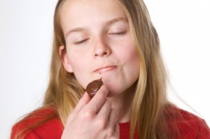 Girl savors the moment as she eats chocolate
